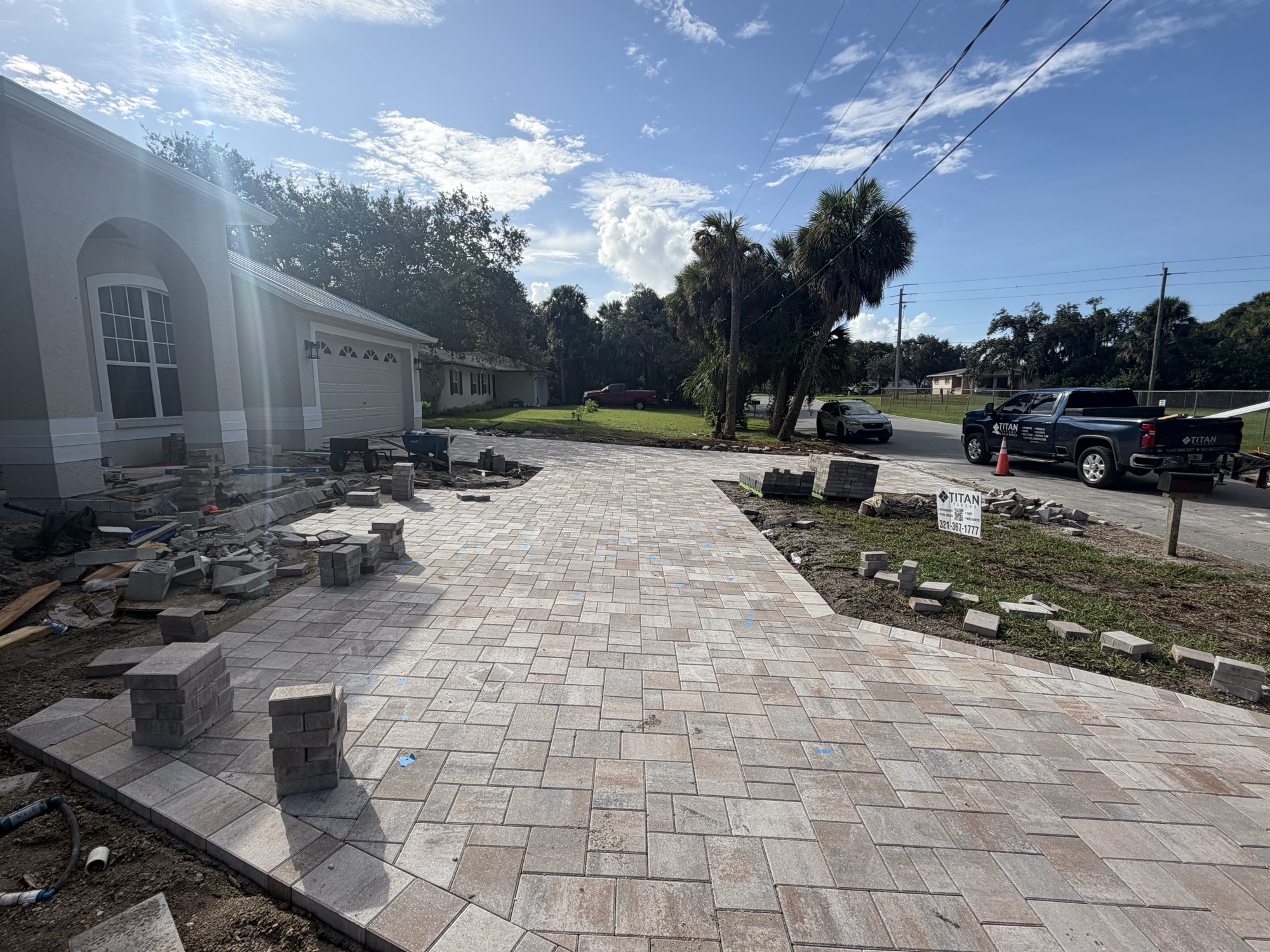 Wide paver field with the Titan Pavers truck and trailer on the street