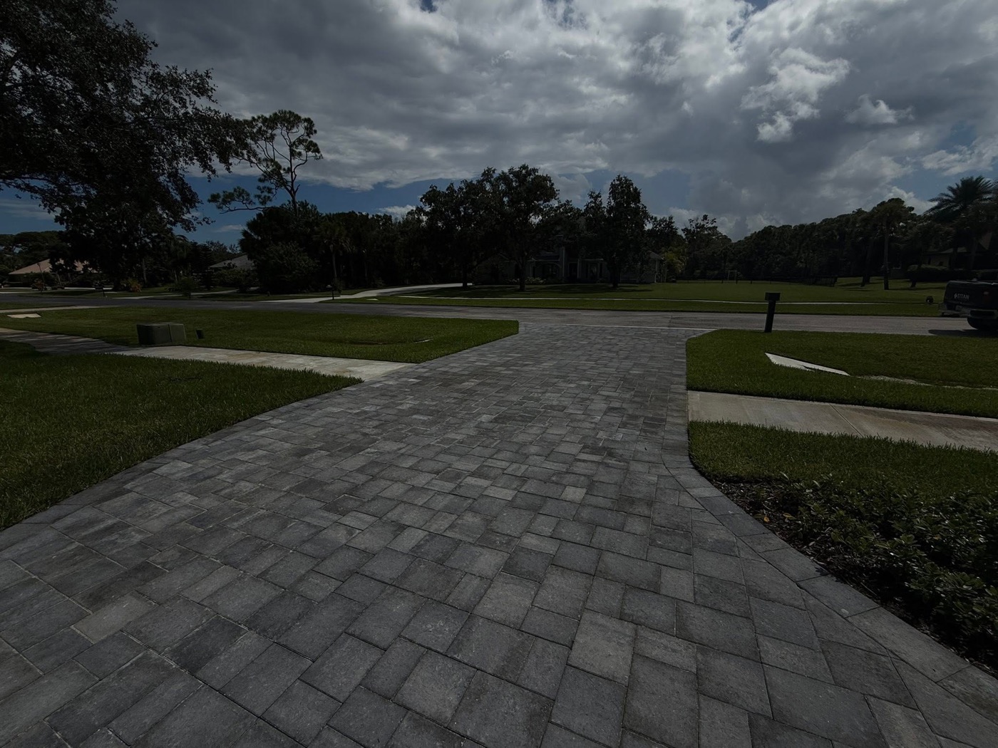 Wide paver driveway under a Florida sky